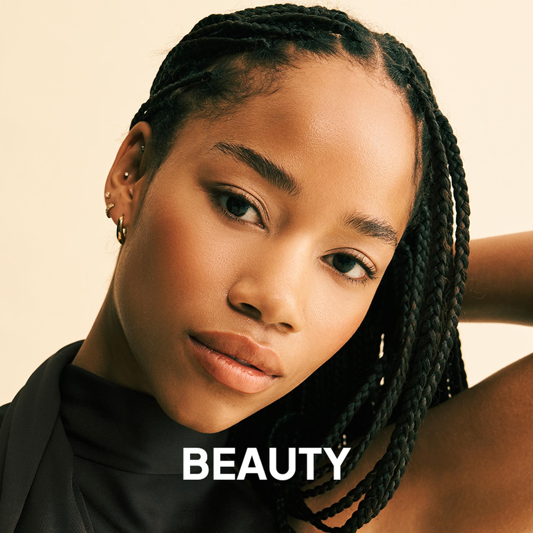 A model wearing a deep red pleated halter neck dress and large silver statement earrings. Beauty and accessories collection.
