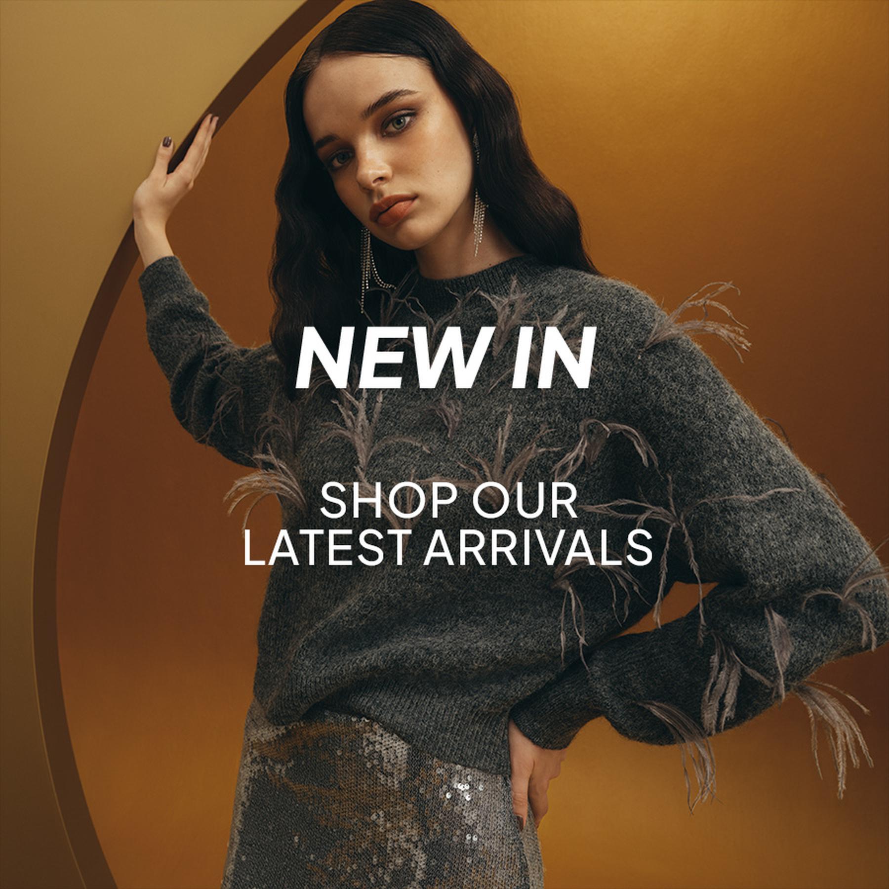 Model posing in a cream blouse, dark mini skirt with a silver disc belt, and black pointed boots. New In: Refresh your wardrobe with our latest arrivals.