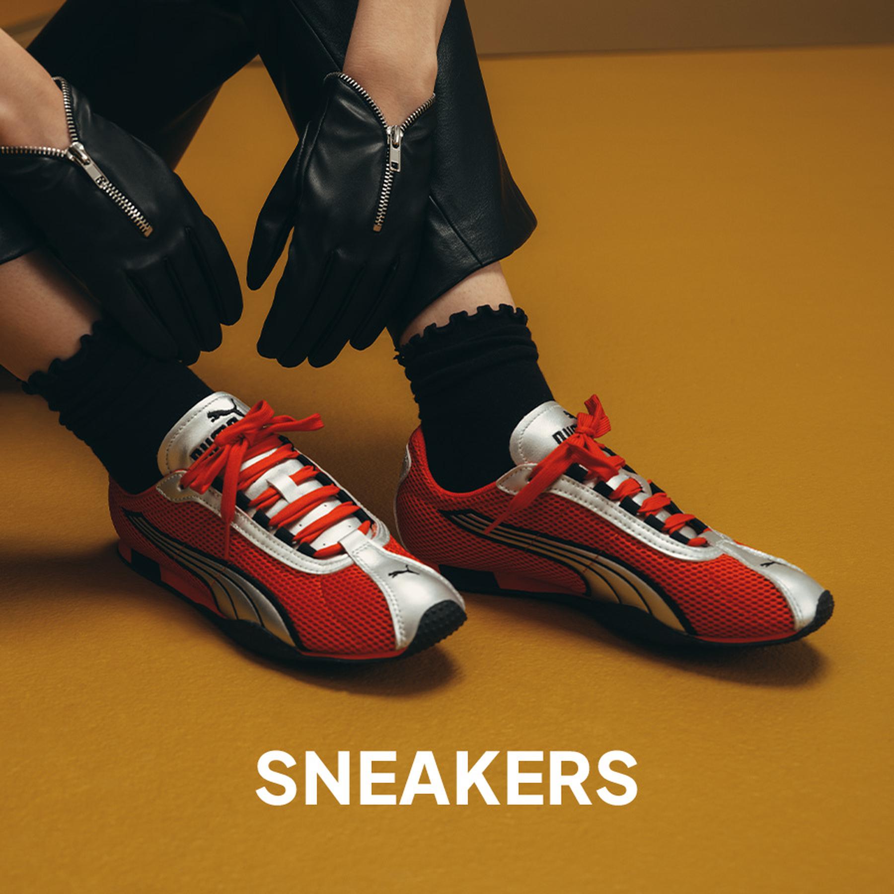 Close-up of cream sneakers with brown stripes paired with white ruffled socks and a lace skirt. Sneakers collection.