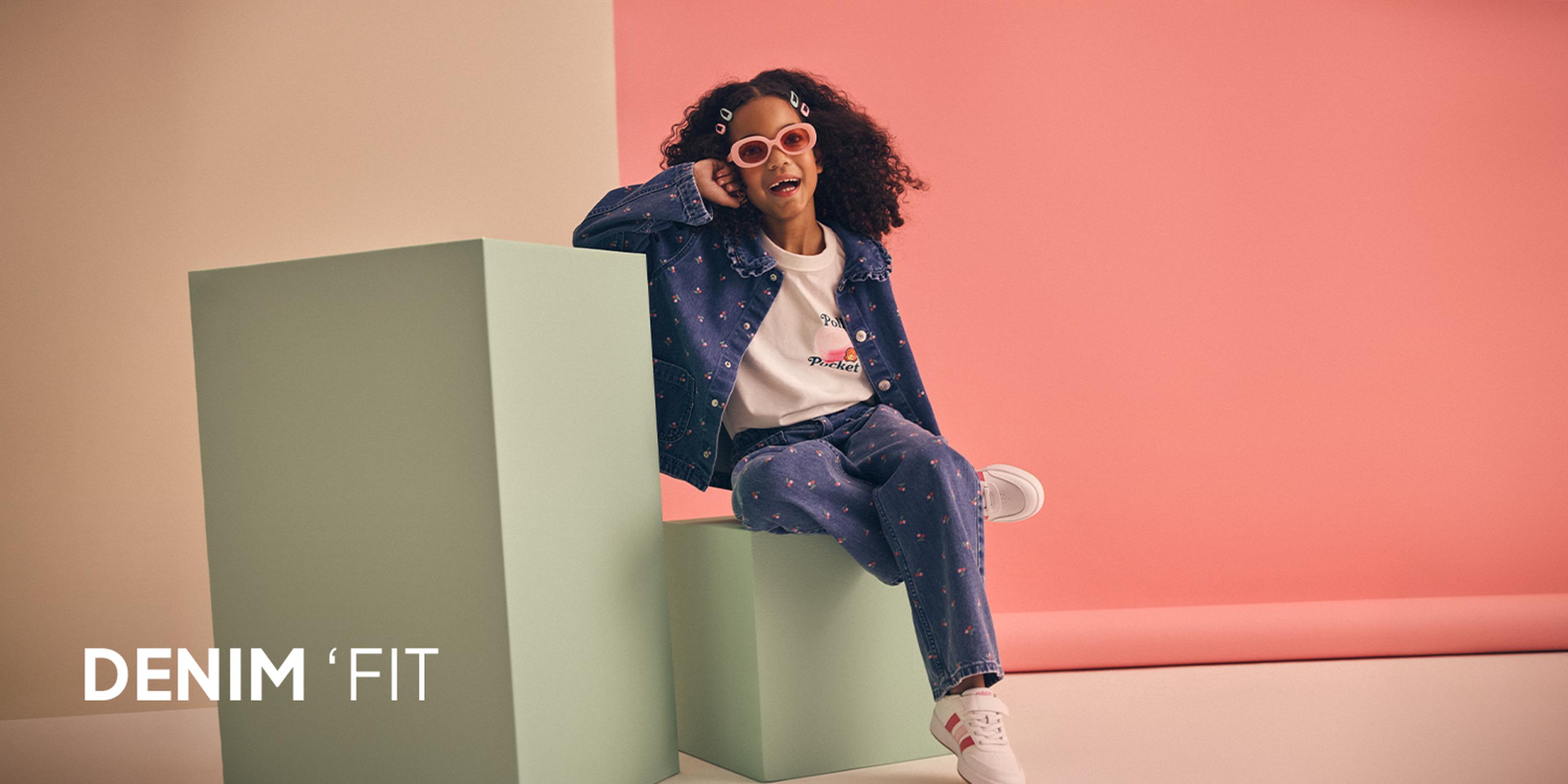 Kids' Cool Kid fashion campaign showcasing a light wash denim utility jacket, matching wide-leg jeans, a bucket hat, and pink trainers.