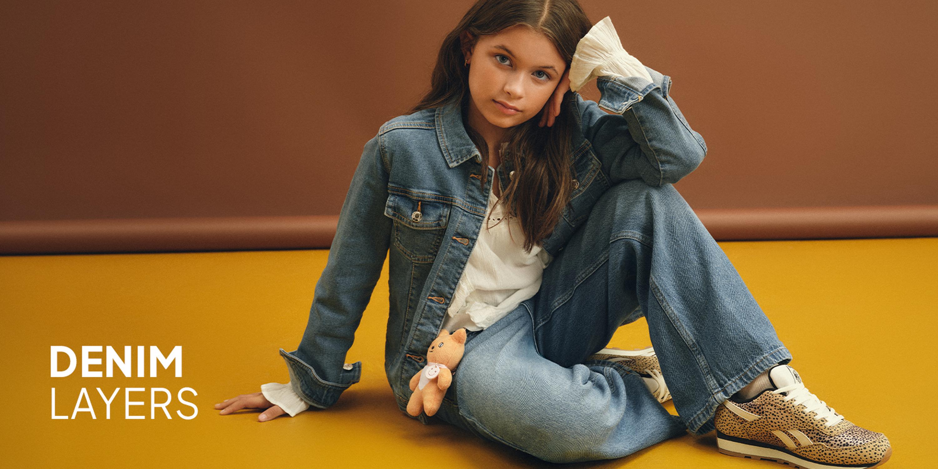 Kids' Cool Kid fashion campaign showcasing a light wash denim utility jacket, matching wide-leg jeans, a bucket hat, and pink trainers.