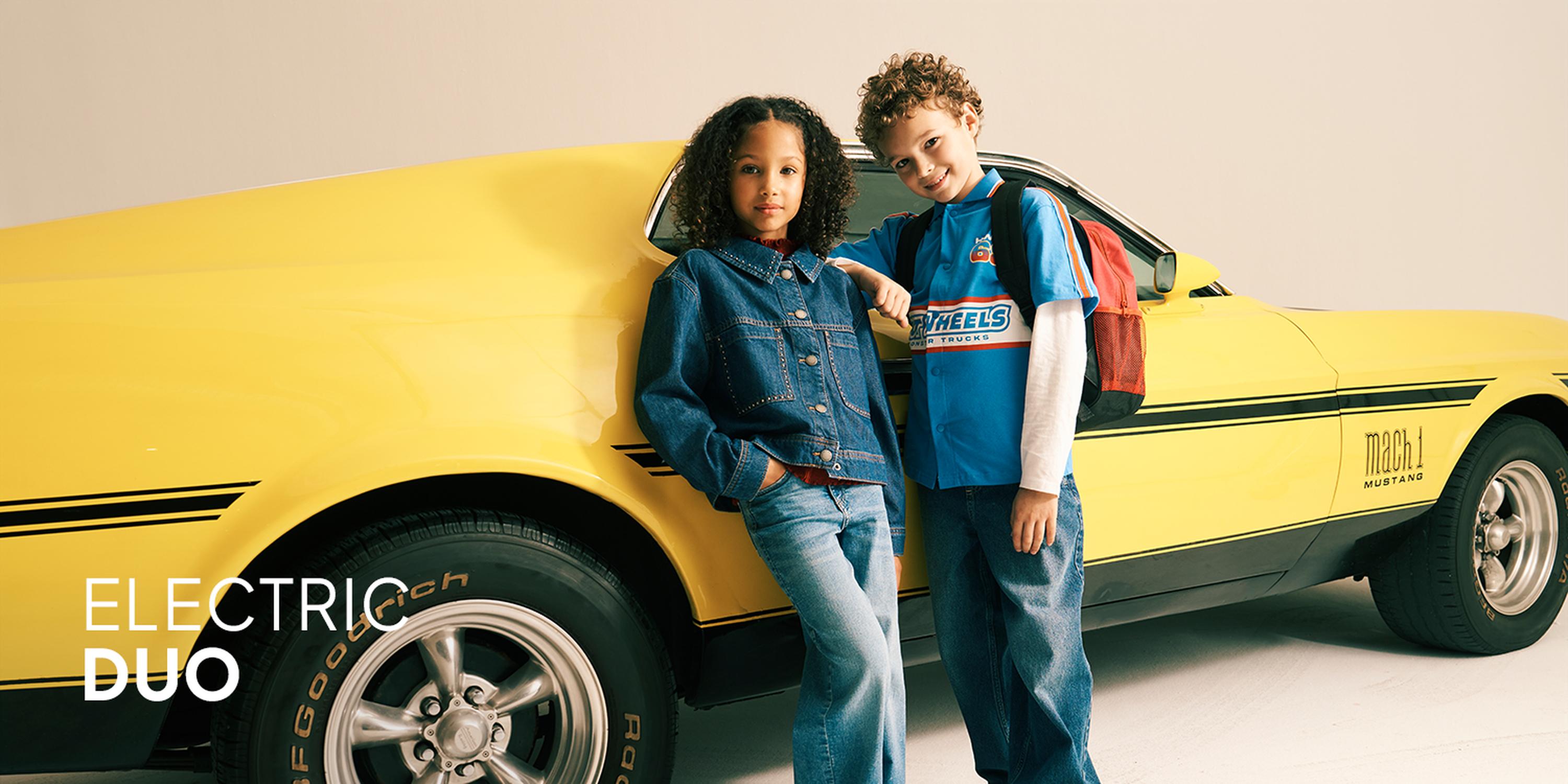 Little Layers promotional image featuring a boy and a girl modeling layered kids' outfits.