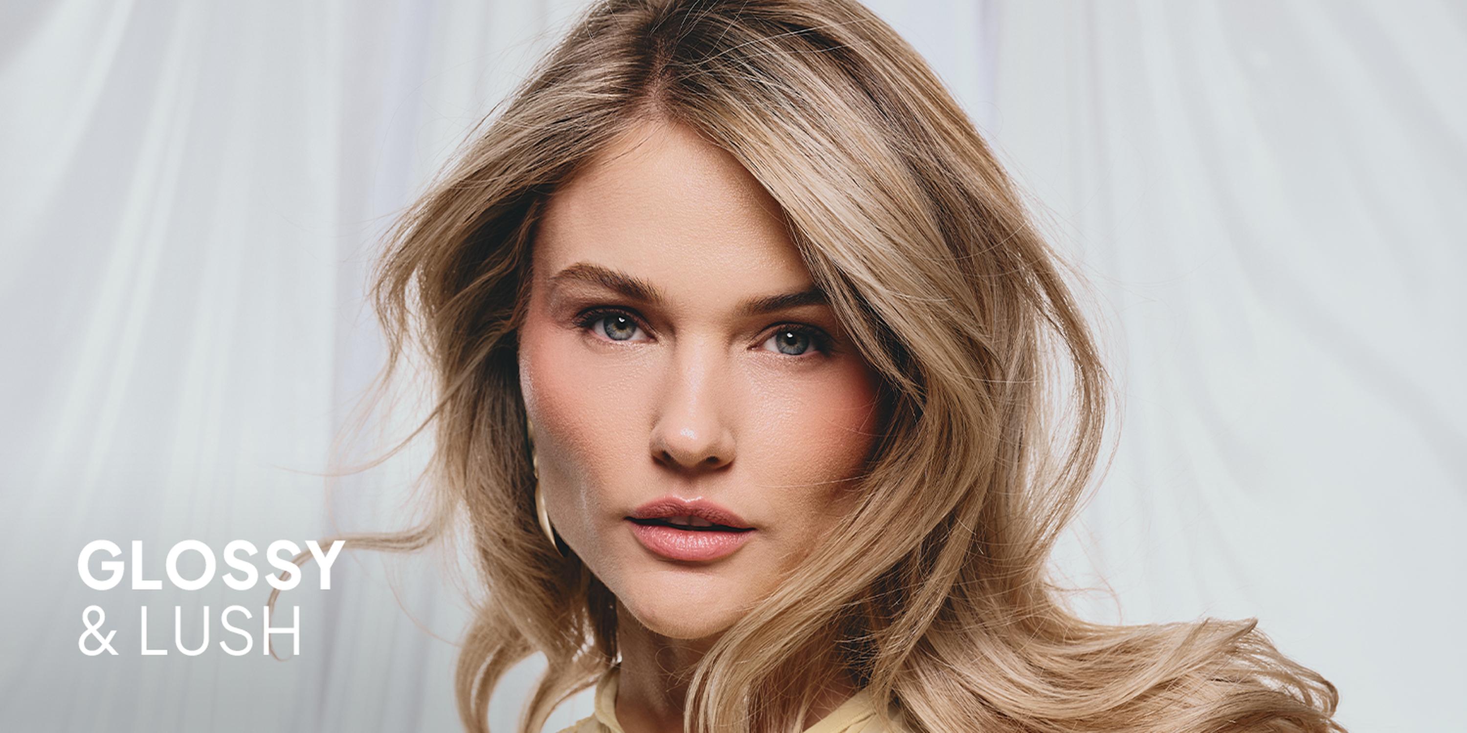 Beauty ad featuring a close-up of a woman with glossy blonde hair on a light background, with the slogan “GLOSSY & LUSH.”
