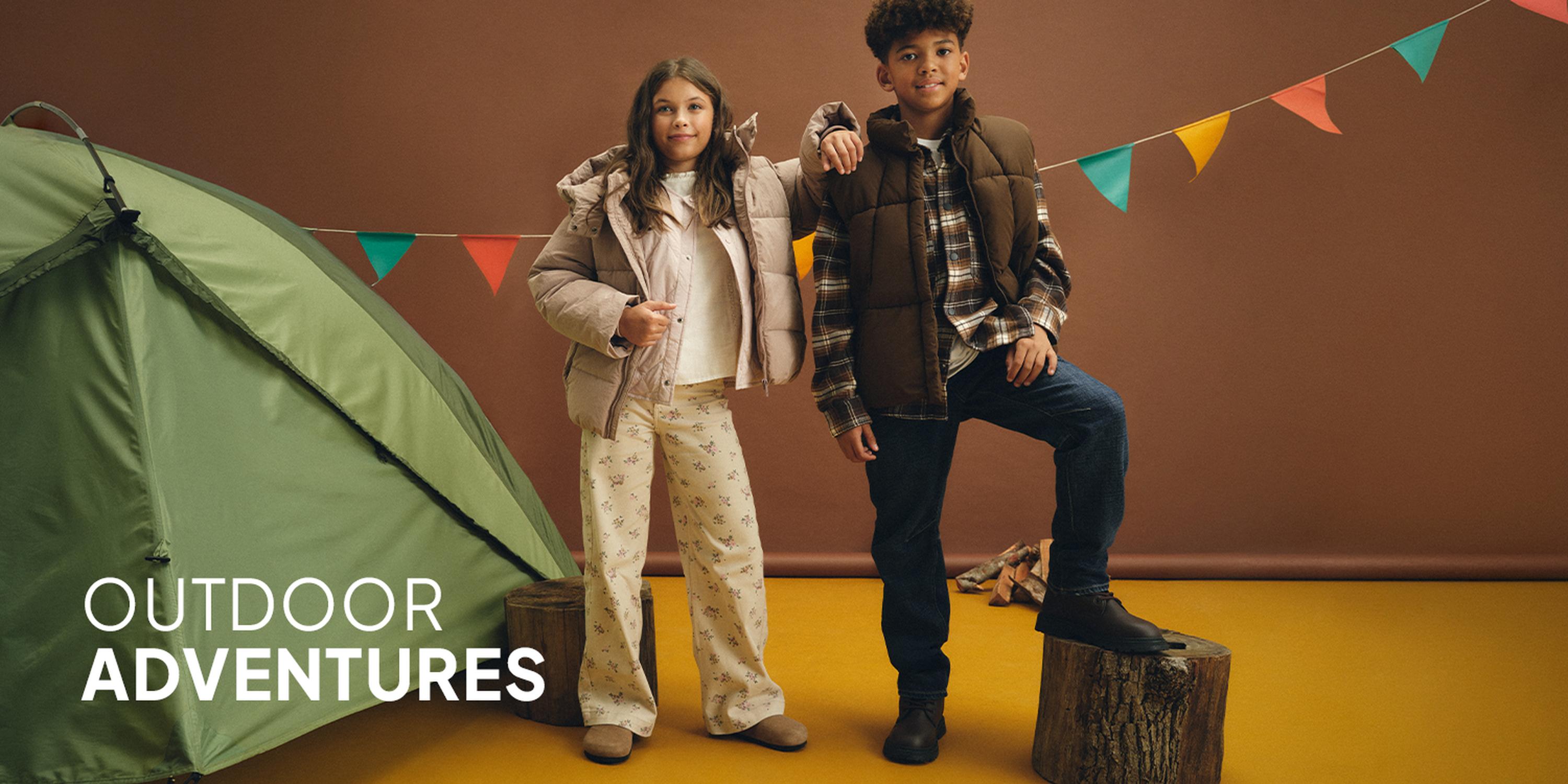 Little Layers promotional image featuring a boy and a girl modeling layered kids' outfits.