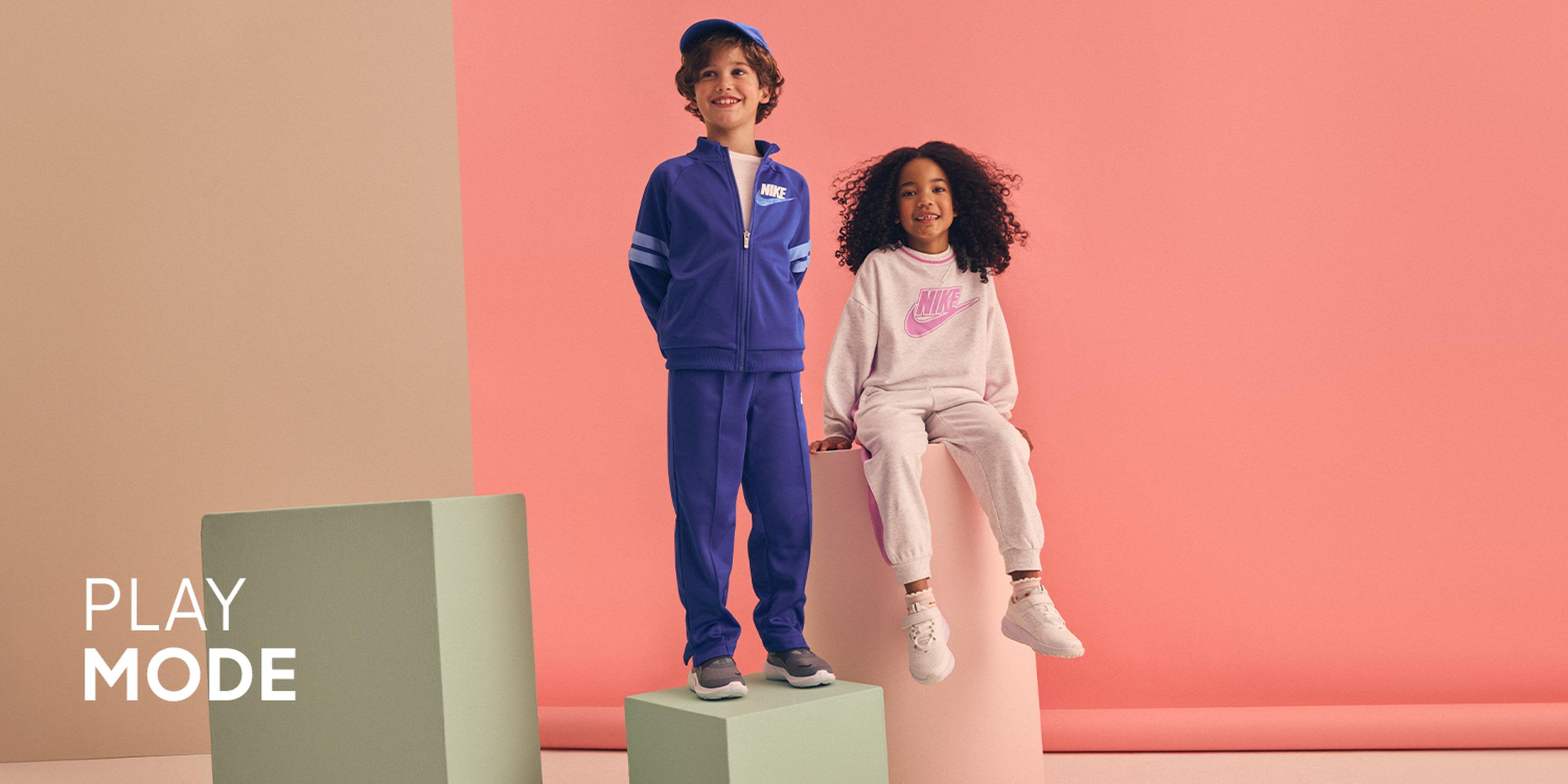 Kids' Woven In fashion collection: Boy wearing a blue puffer vest over a cream striped knit sweater, khaki joggers, and tan lace-up boots.