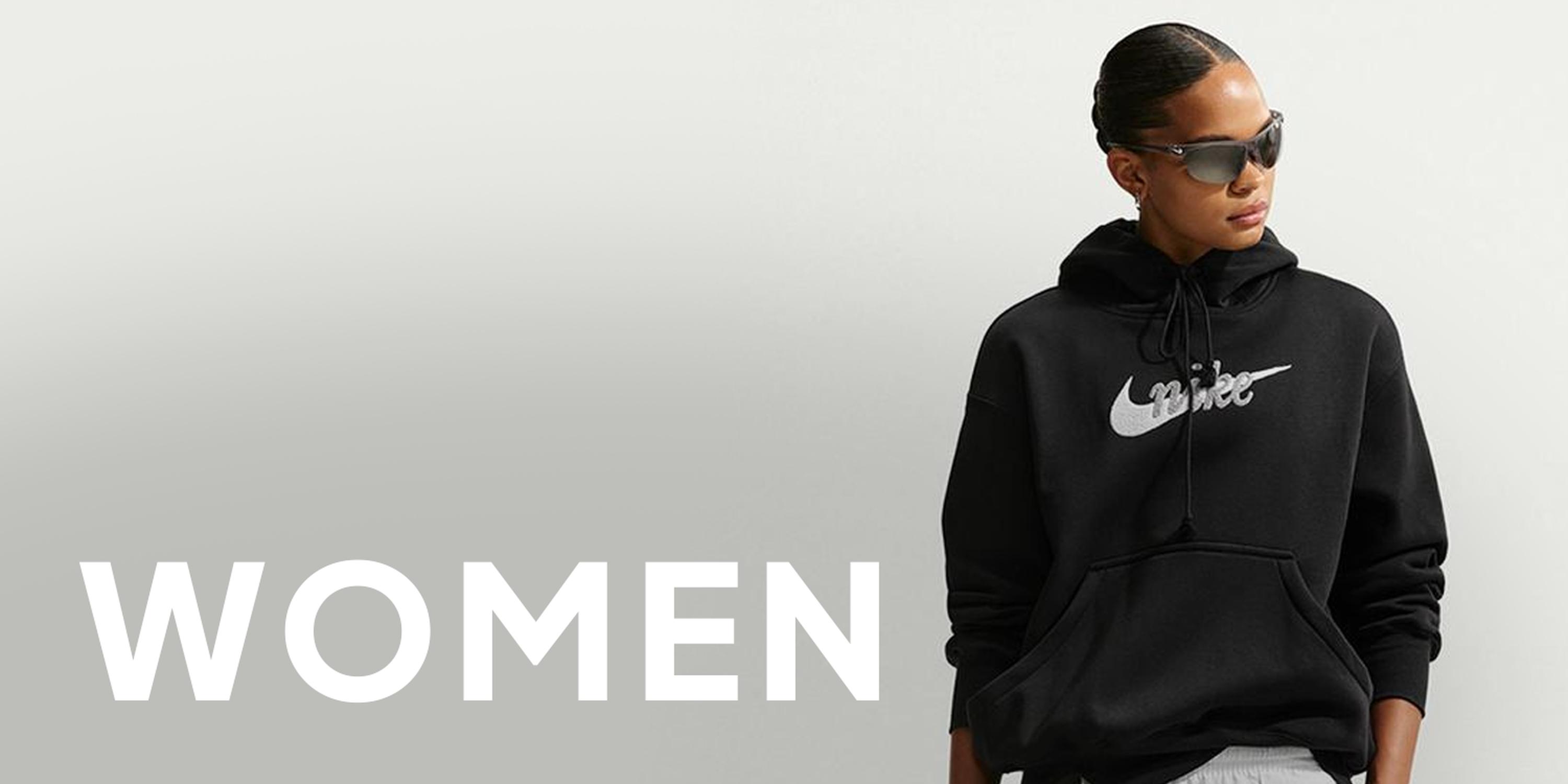 Black Friday Nike women’s section banner featuring a woman in a black hoodie and sunglasses, with large “WOMEN” text on a light gray background.