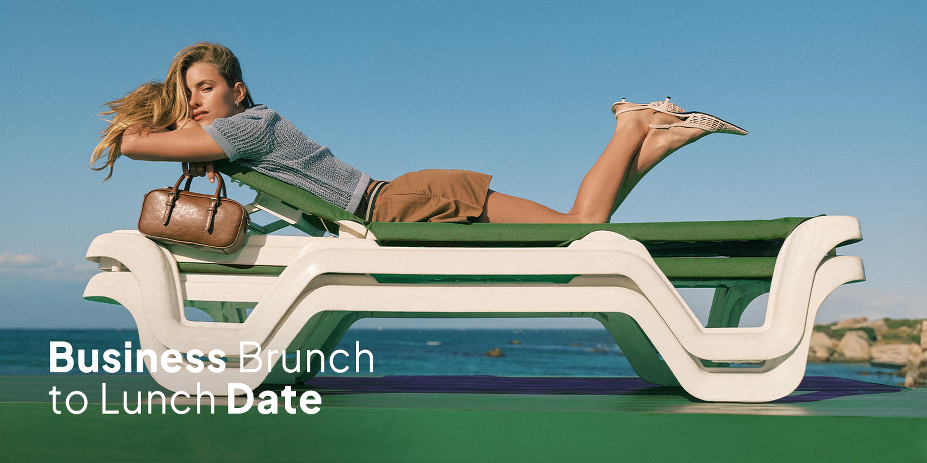 Fashion campaign banner of a woman lounging on a green-and-white sunbed by the sea, wearing a striped top and tan skirt with heels, holding a brown handbag, overlaid with the text “Business Brunch to Lunch Date.”