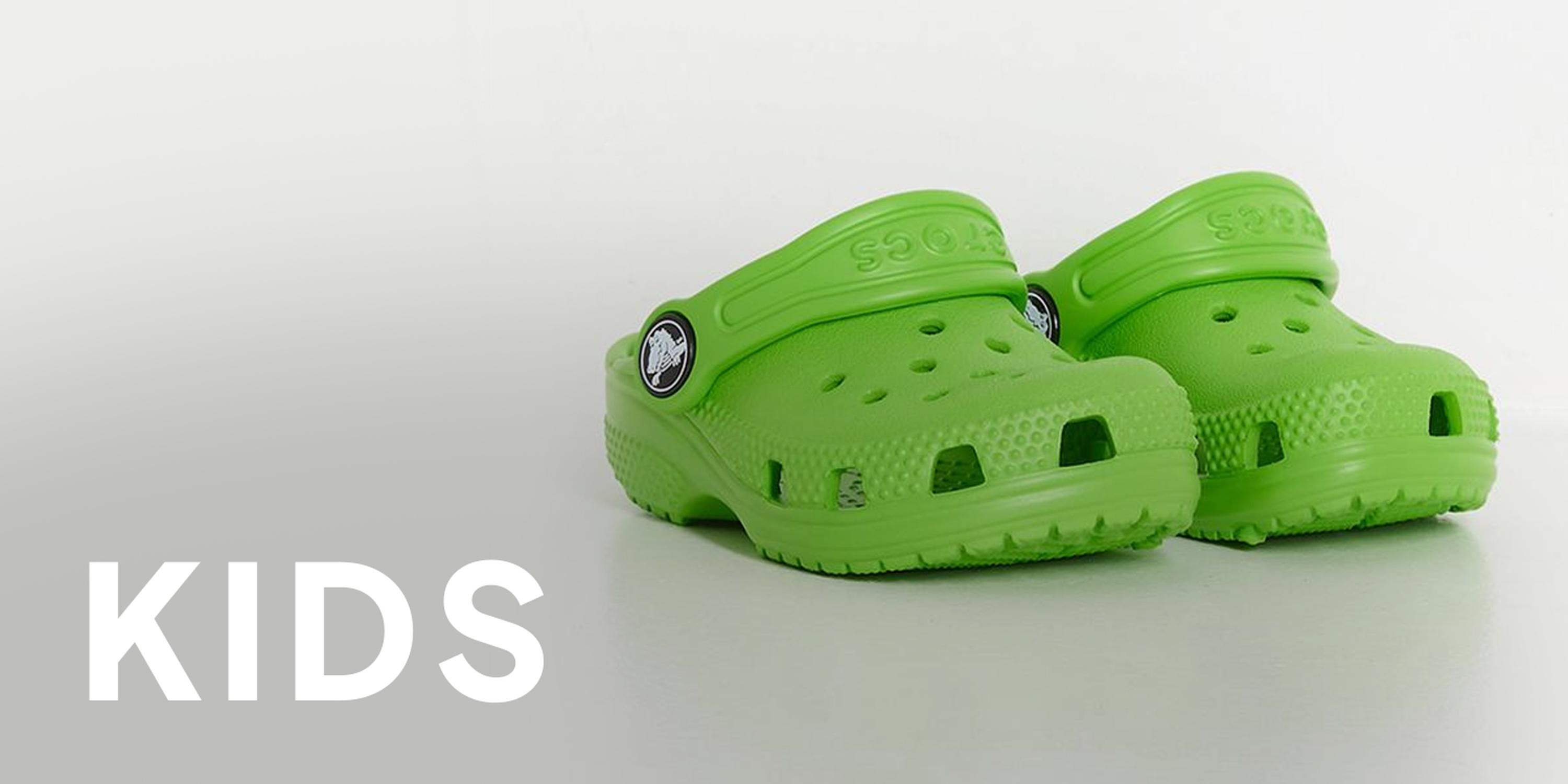Black Friday kids section featuring bright green Crocs clogs on a light background