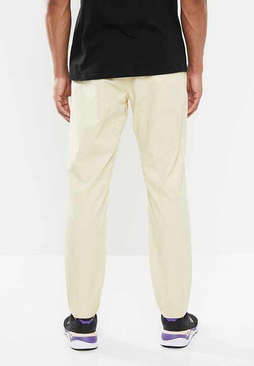 New Balance  - New Balance  athletics woven pant - beige 