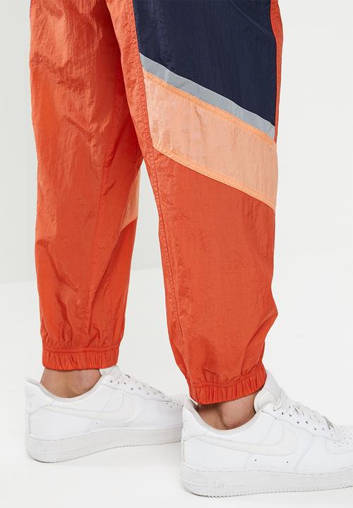 Nike - Nike sportswear he wr+ unld woven pants - orange & navy