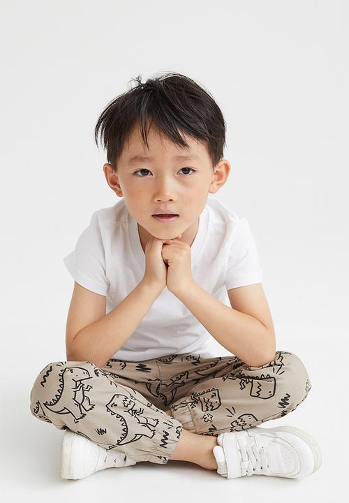 H&M - Relaxed fit joggers - beige/dinosaurs