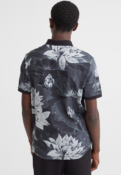 H&M - Slim fit patterned polo shirt - black/lotus flowers