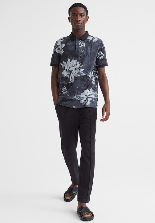 H&M - Slim fit patterned polo shirt - black/lotus flowers