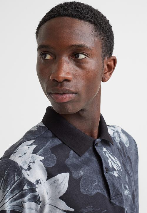 H&M - Slim fit patterned polo shirt - black/lotus flowers