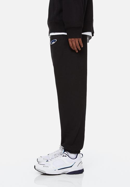 H&M - Relaxed fit printed sweatpants - black/boring pals
