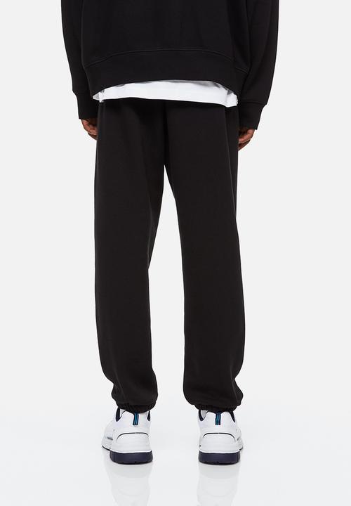 H&M - Relaxed fit printed sweatpants - black/boring pals