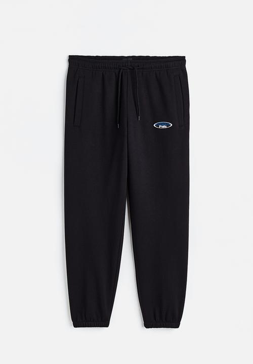 H&M - Relaxed fit printed sweatpants - black/boring pals