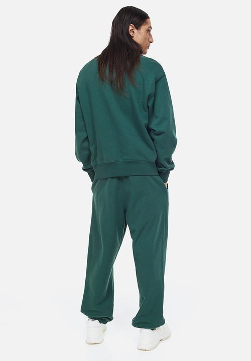 H&M - Loose fit printed sweatpants - dark green/boring pals