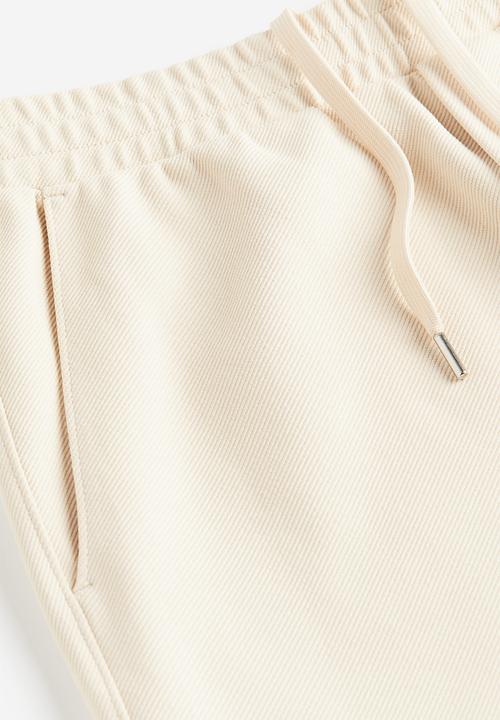 H&M - Slim fit twill joggers - beige white