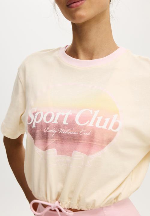 Cotton On - Active Graphic Tie Up Tee - Coconut Milk/Sport Club