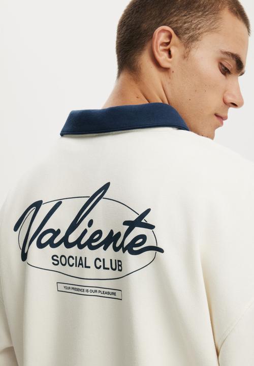 Cotton On - Cropped Fit Graphic Fleece Polo - Chalk White/Auto Navy/Valiente