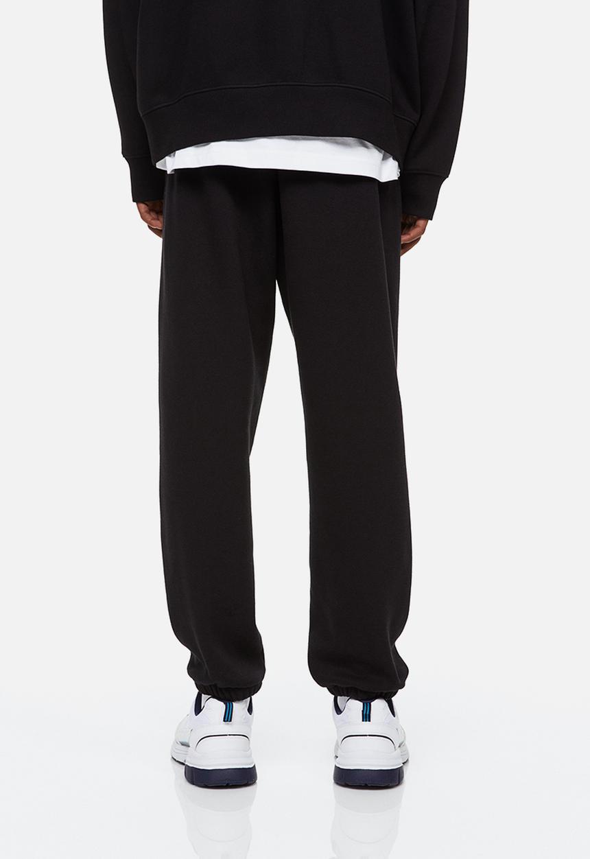 H&M - Relaxed fit printed sweatpants - black/boring pals