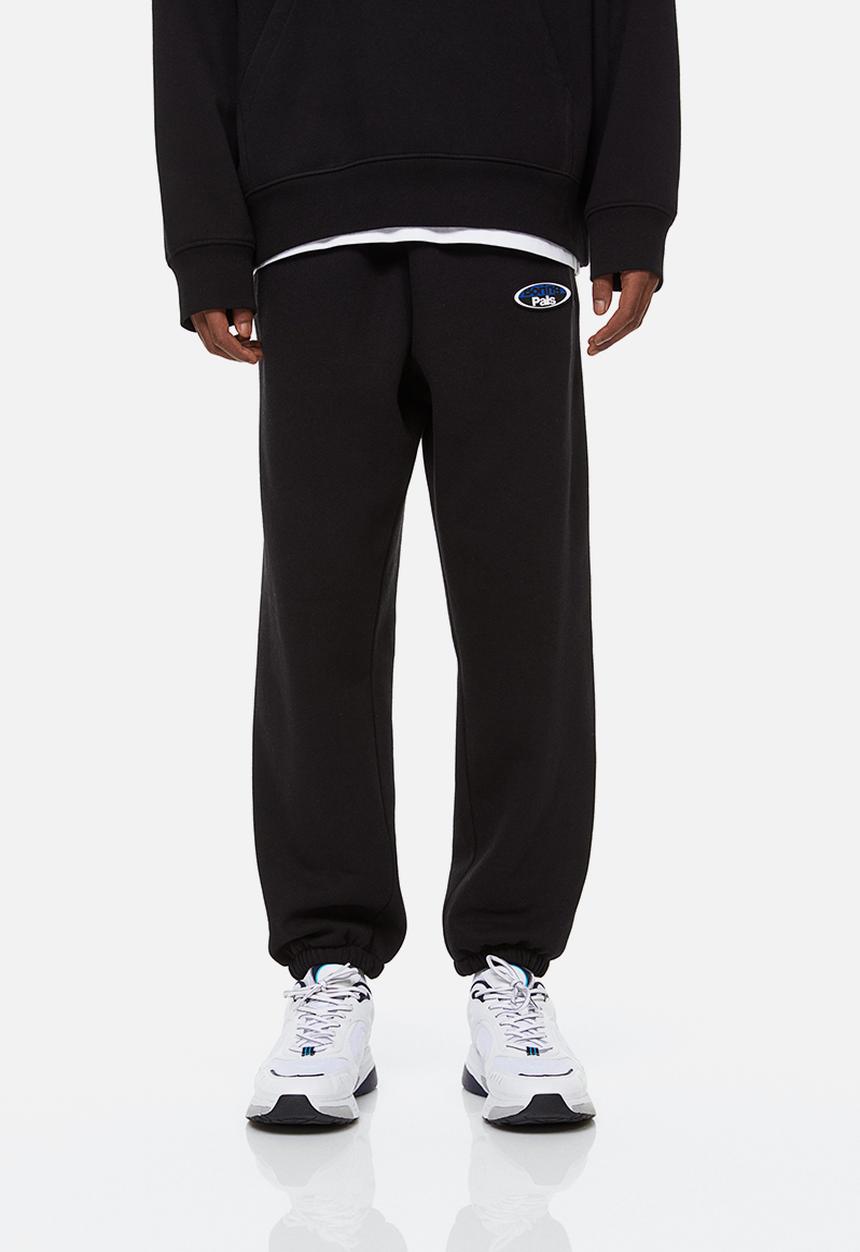 H&M - Relaxed fit printed sweatpants - black/boring pals