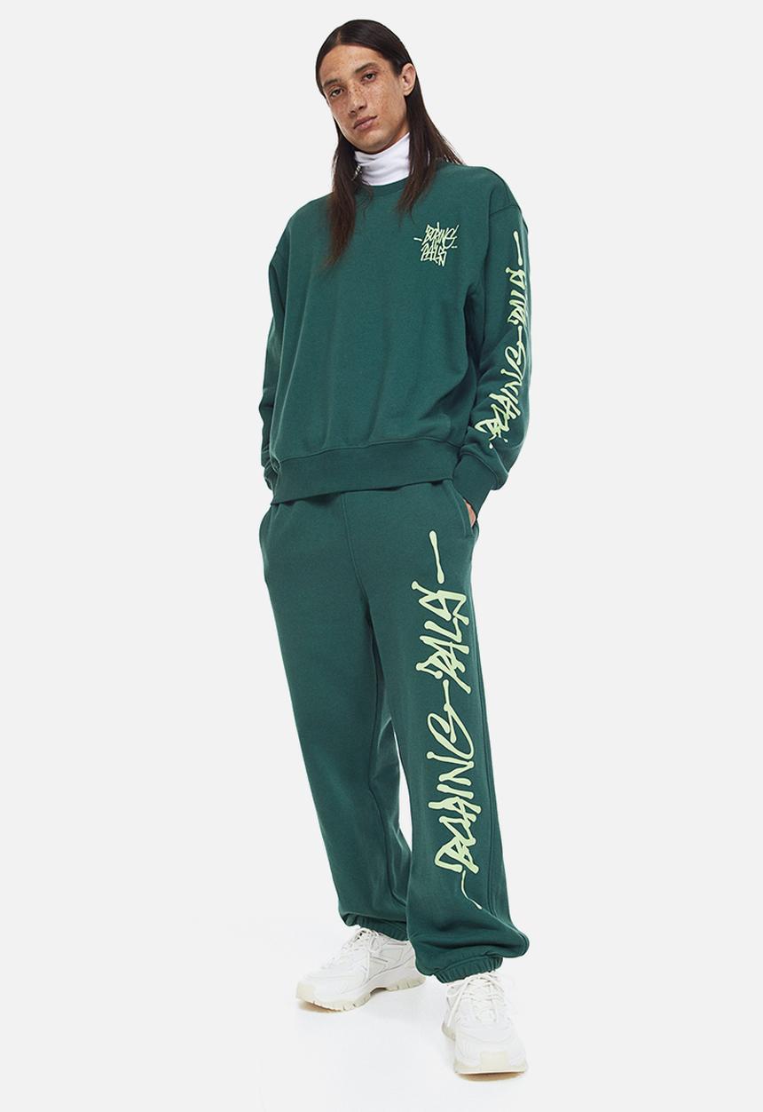H&M - Loose fit printed sweatpants - dark green/boring pals