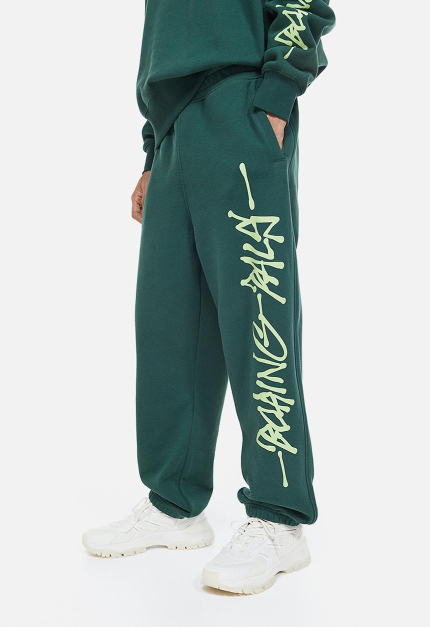 H&M - Loose fit printed sweatpants - dark green/boring pals