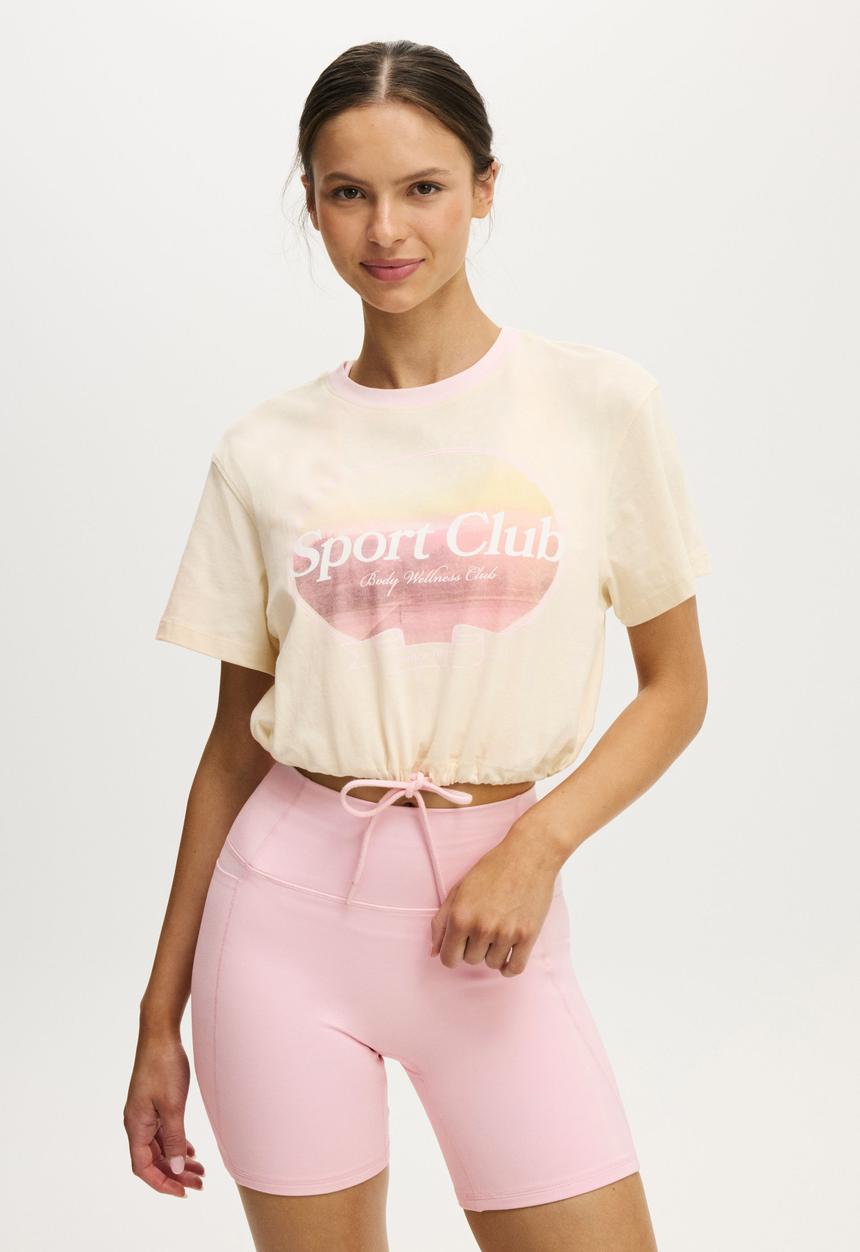 Cotton On - Active Graphic Tie Up Tee - Coconut Milk/Sport Club