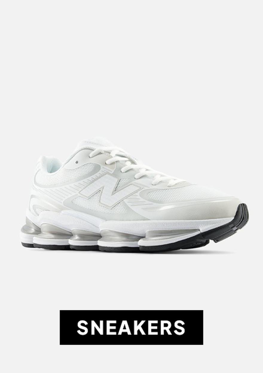 White New Balance sneaker on a light background with a black friday “SNEAKERS” label below.