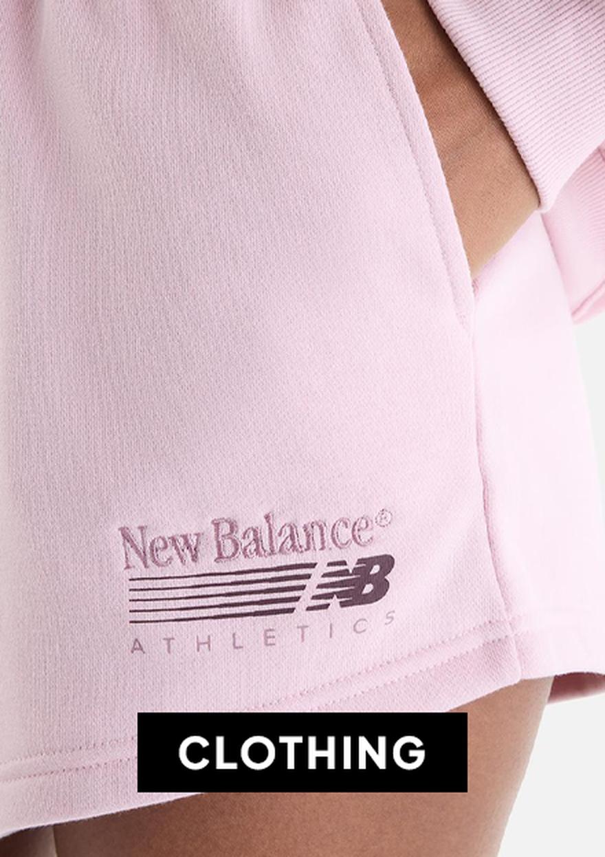 Close-up of a woman wearing a light pink New Balance Athletics cropped T-shirt and matching shorts, with a black friday “CLOTHING” label overlay.