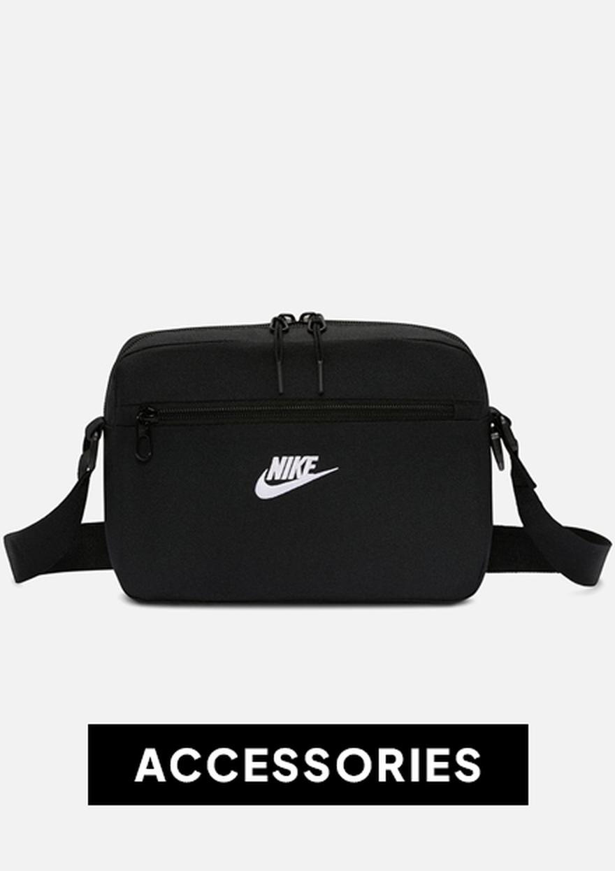 Black Nike crossbody bag on a white background with a bold “ACCESSORIES” label below.