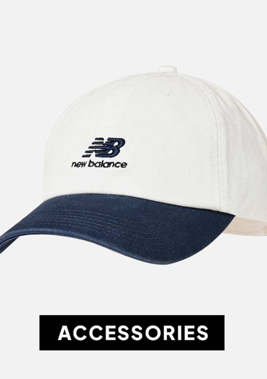White and navy New Balance baseball cap on a light background with a black “ACCESSORIES” label, for Black Friday deals including kids' items.